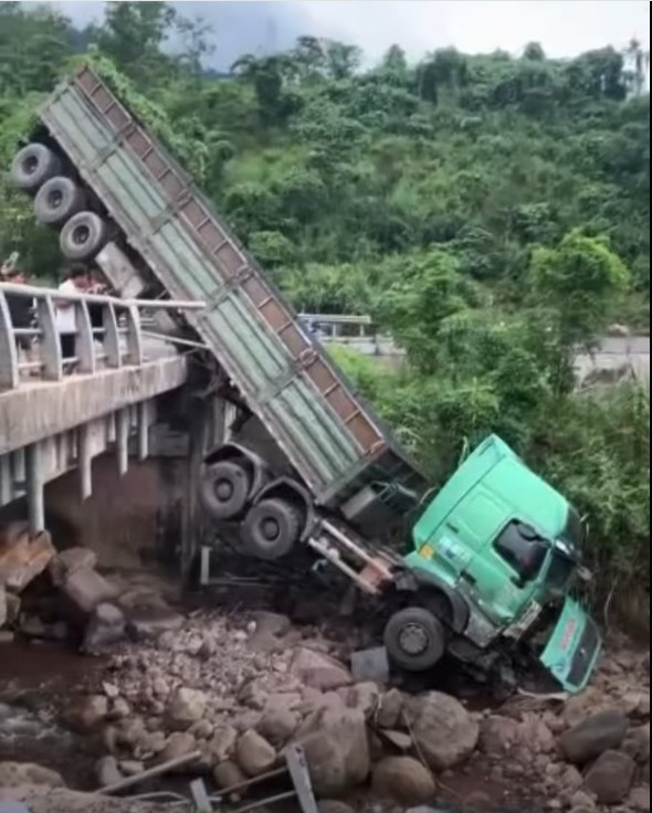 Xe tải lao xuống cầu, thùng xe chổng lên khiến đường lên cửa khẩu quốc tế bị tắc- Ảnh 3. Chiếc xe nằm nửa trên nửa dưới cầu - Ảnh: HỌA MY