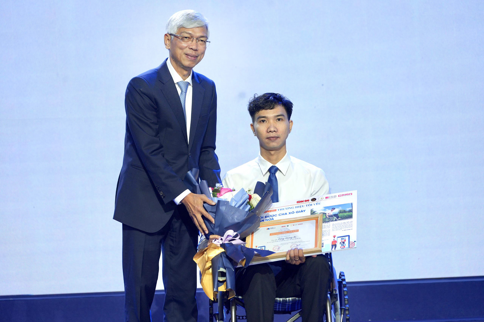 Phó chủ tịch UBND TP.HCM Võ Văn Hoan trao giải nhất cuộc thi “Thương hiệu tôi yêu” cho tác giả Đặng Hoàng An với bài “Ngoài 30 tuổi, tôi được cha xỏ giày vào chân một lần nữa” - Ảnh: HỮU HẠNH