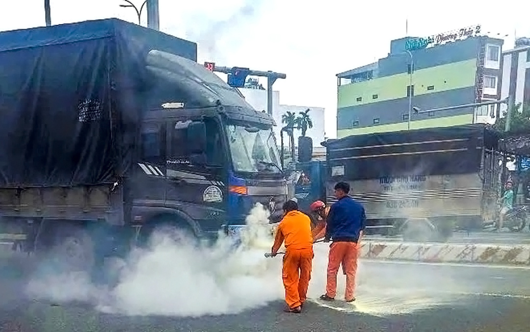 Công nhân điện lực kịp thời dập tắt đám cháy trên đường - Ảnh 1. Công nhân điện lực kịp thời dập tắt đám cháy trên đường - Ảnh 1.