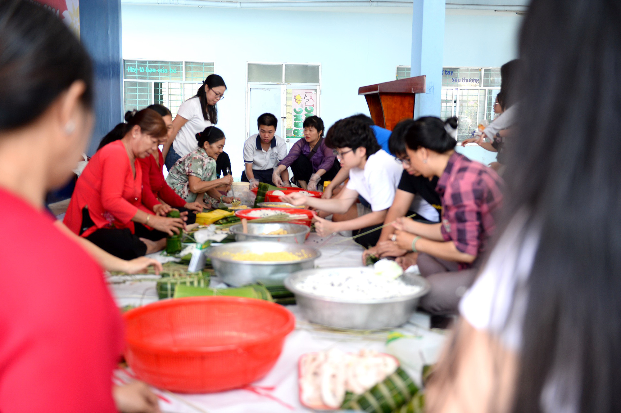 Tết ấm áp với người nghèo- Ảnh 6. Phụ huynh và học sinh Trường Đinh Thiện Lý (quận 7) chung tay gói bánh tét làm quà tặng người nghèo - Ảnh: HẢI QUỲNH