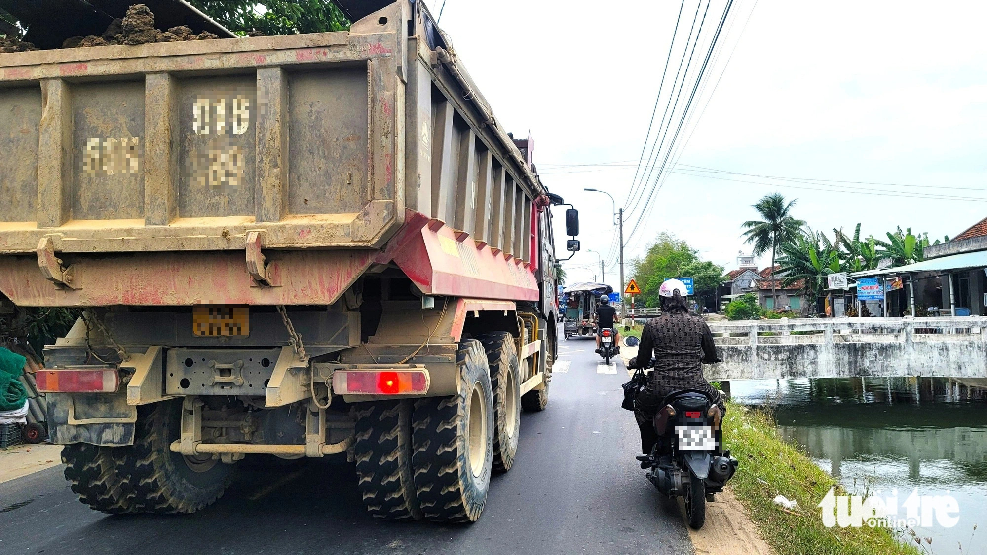 Xe tải chở vật liệu xây dựng chạy gần hết làn đường trên quốc lộ 25 nên nhiều người đi xe máy sợ va chạm phải né ra để xe này chạy - Ảnh: NGUYỄN HOÀNG Xe tải chở vật liệu xây dựng chạy gần hết làn đường trên quốc lộ 25 - Ảnh: NGUYỄN HOÀNG