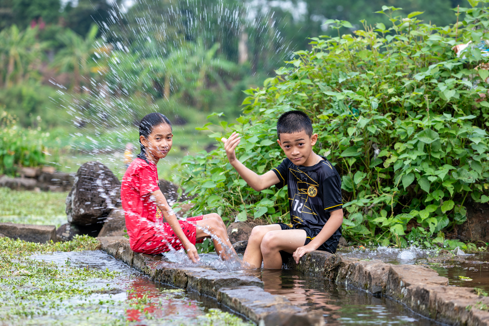 Tắm mát ở giếng cổ 2.000 năm tuổi trong chuỗi ngày nóng kỷ lục miền Trung- Ảnh 1. Trẻ em đến chơi, tắm mát ở các giếng cổ Gio An - Ảnh: HOÀNG TÁO
