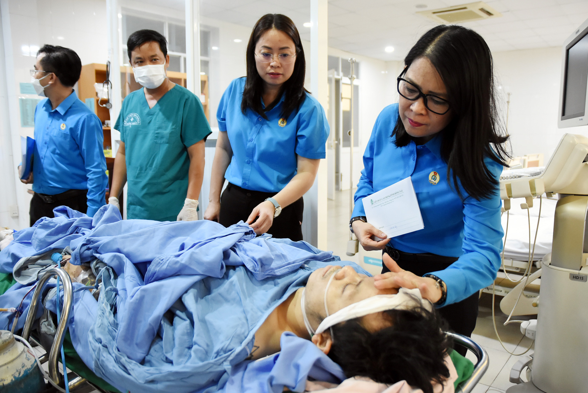 Vụ nổ lò hơi làm 6 người chết: Nỗ lực cứu chữa người bị thương- Ảnh 3. Lãnh đạo Liên đoàn Lao động tỉnh Đồng Nai ân cần thăm hỏi một nạn nhân vụ nổ lò hơi đang điều trị tại bệnh viện - Ảnh: A LỘC