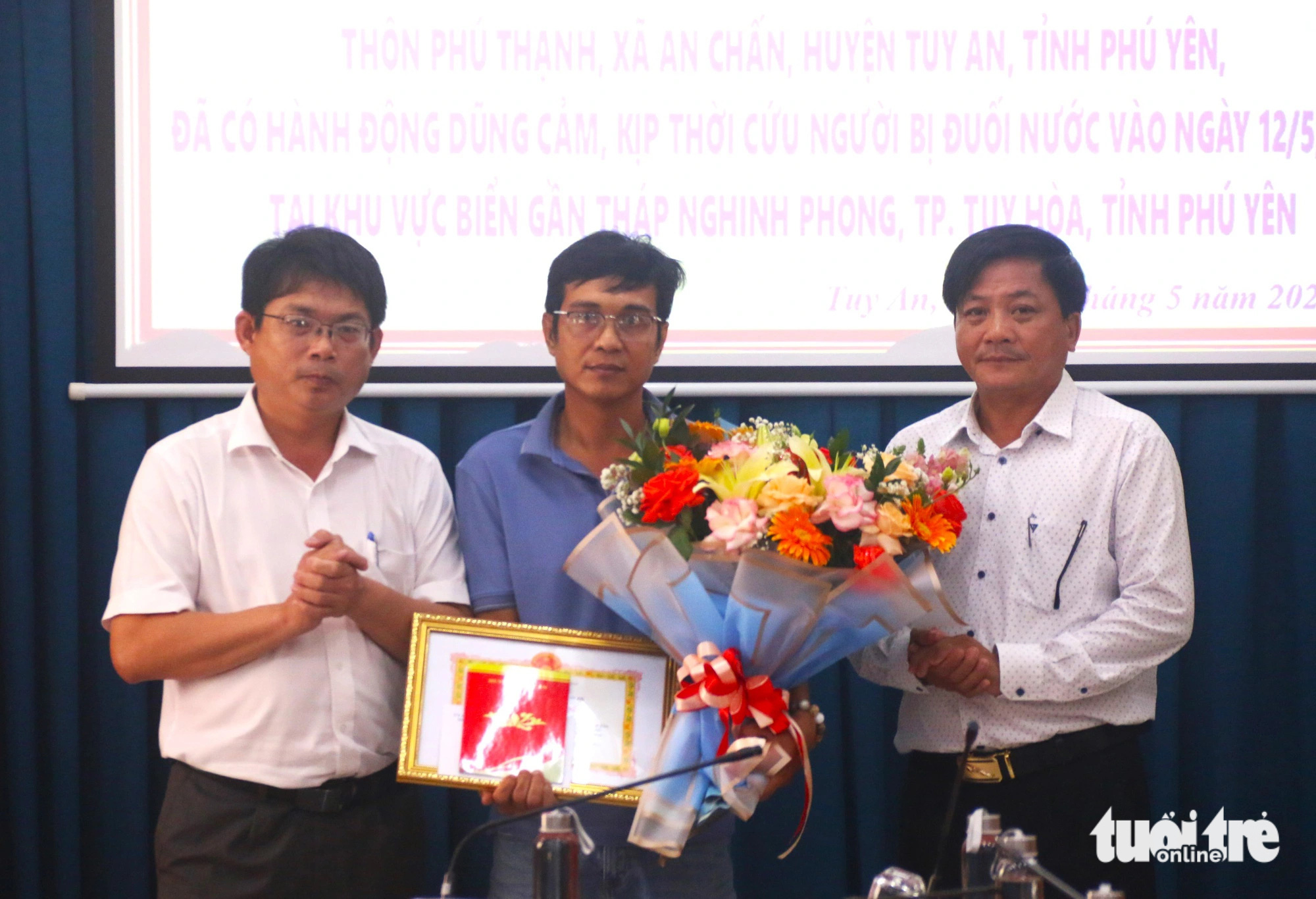 Phó bí thư huyện ủy, chủ tịch UBND huyện Tuy An Huỳnh Gia Hoàng (ngoài cùng bên trái) trao bằng khen, phần thưởng cho anh Trần Văn Tính (giữ) vì có hành động dũng cảm cứu người bị đuối nước - Ảnh: NGUYỄN HOÀNG Chủ tịch UBND huyện Tuy An Huỳnh Gia Hoàng (ngoài cùng bên trái) trao bằng khen cho anh Trần Văn Tính (giữa) vì có hành động dũng cảm cứu người bị đuối nước - Ảnh: NGUYỄN HOÀNG