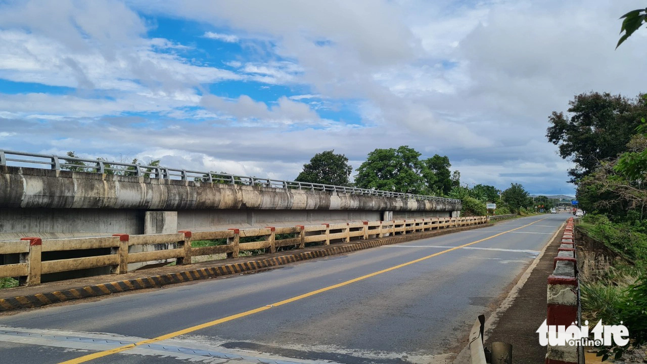 Dự án kết thúc 6 năm, cầu nối hai tỉnh trên quốc lộ 14 vẫn bỏ hoang- Ảnh 2. Cầu mới chưa thông nên xe vẫn đi lại trên cầu cũ - Ảnh: TÂM AN