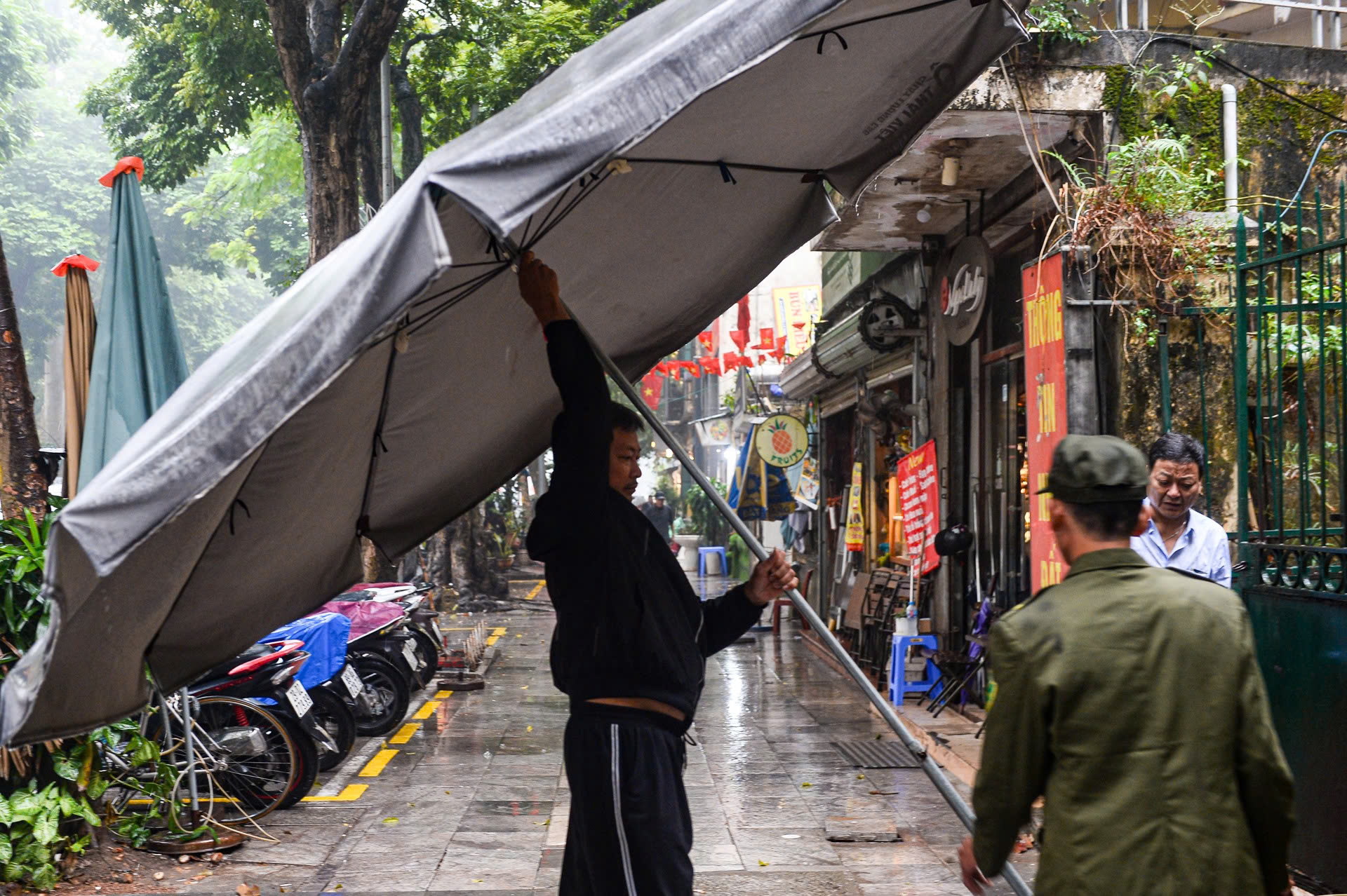 Công an Hà Nội đội mưa đồng loạt ra quân giành lại vỉa hè, lòng đường - Ảnh 8.