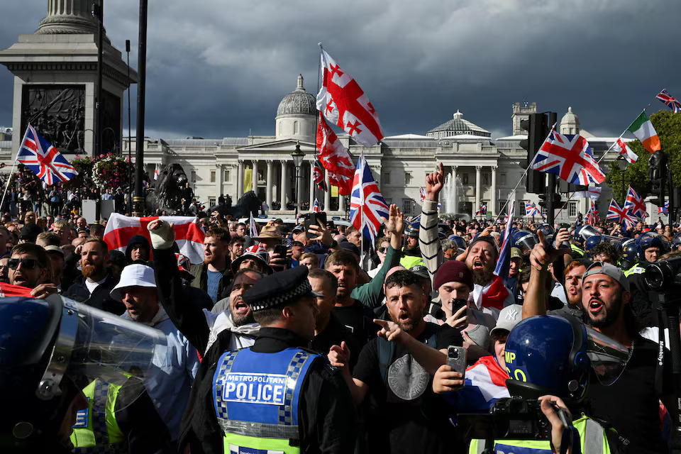 Police and protesters scuffle as 110,000 join anti-migrant London protest- Ảnh 1.
