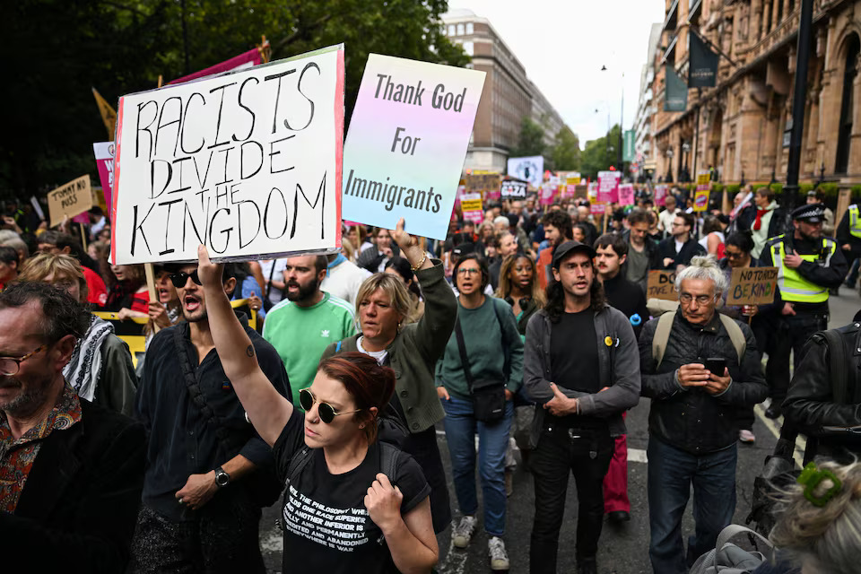 Police and protesters scuffle as 110,000 join anti-migrant London protest- Ảnh 11.