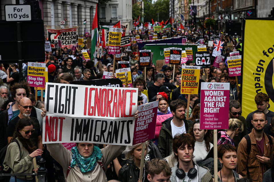 Police and protesters scuffle as 110,000 join anti-migrant London protest- Ảnh 7.