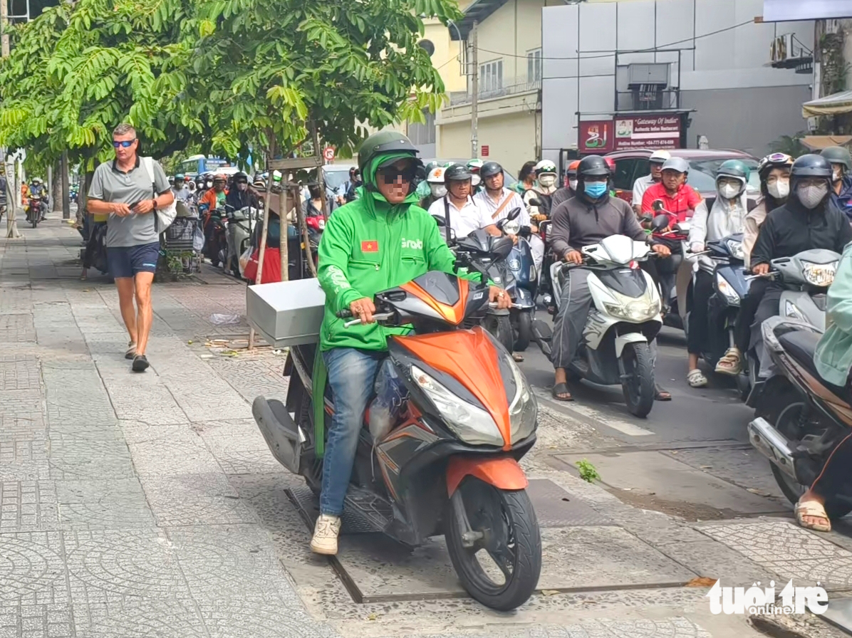Motorbikes flood sidewalks in Ho Chi Minh City despite heavy fines- Ảnh 7.