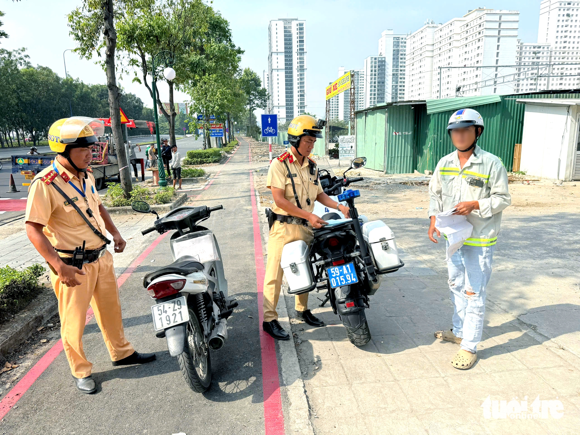 Cảnh sát giao thông xử phạt người chạy xe máy vào làn dành riêng cho xe đạp trên đường Mai Chí Thọ - Ảnh 1.