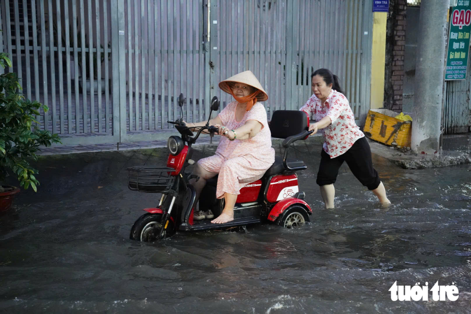 Ho Chi Minh City streets flooded as tide reaches 1.71m - Ảnh 12.