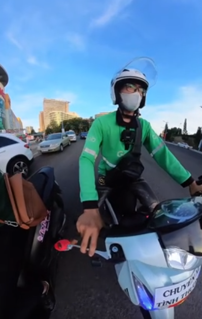Vietnamese ride-hailing driver pushes Chinese tourist’s broken-down scooter, refuses reward- Ảnh 1.