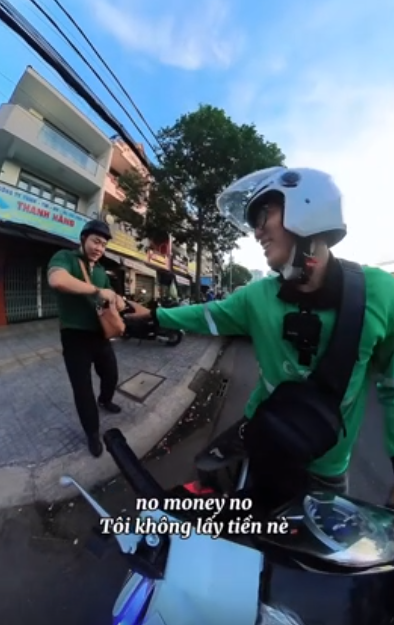 Vietnamese ride-hailing driver pushes Chinese tourist’s broken-down scooter, refuses reward- Ảnh 2.