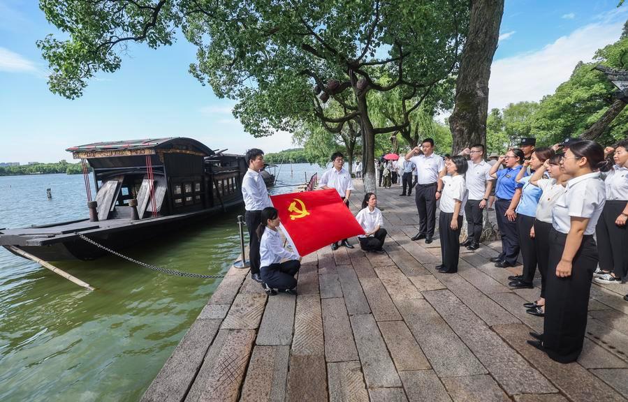 Members of the Chinese Communist Party recite their party membership oaths next to a replica of the boat, now known as the Red Boat, in June 2025. This is where the founders of the Chinese Communist Party concluded their conference in 1921