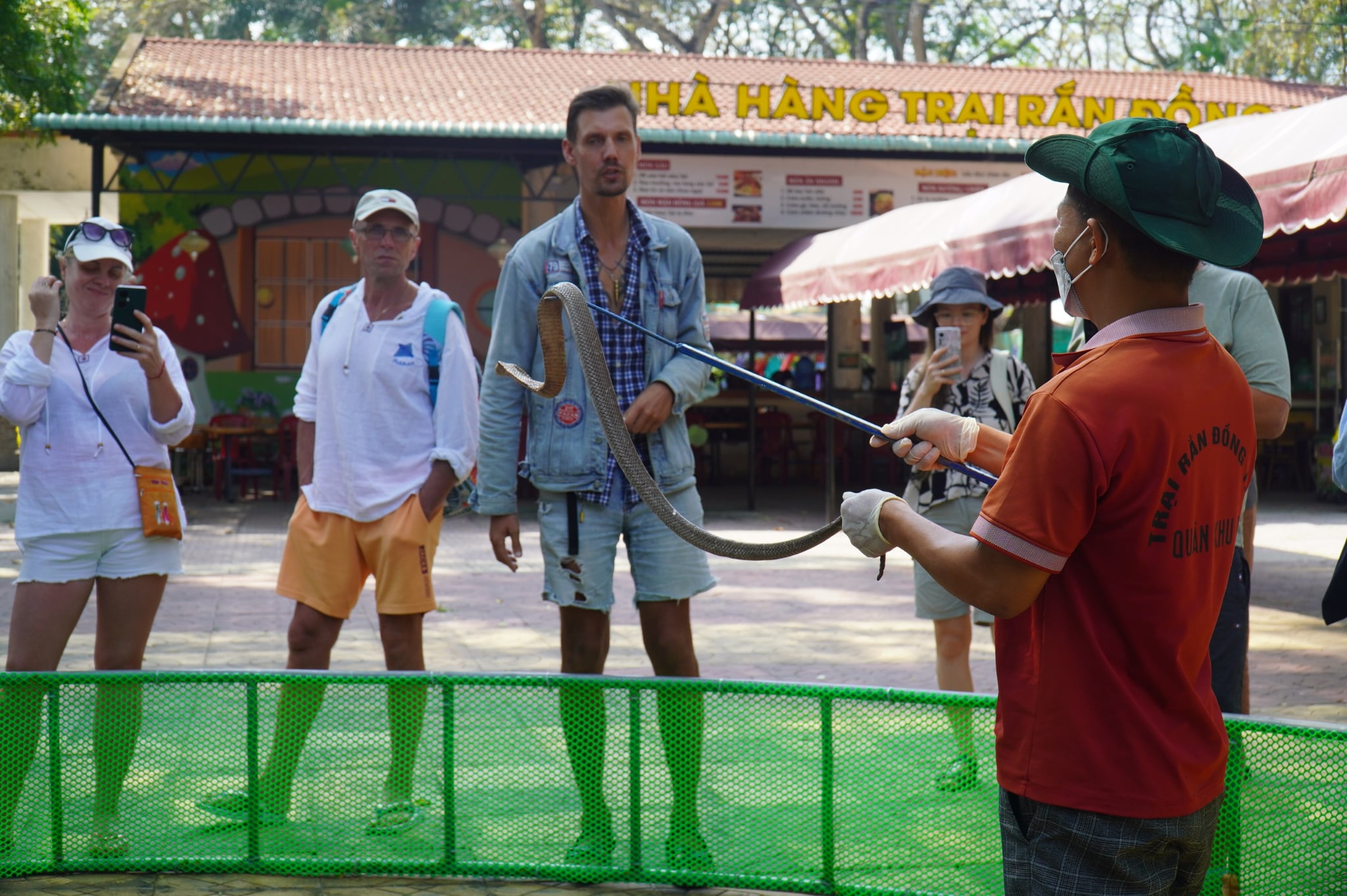 Foreign tourists embrace snakes for photos at snake farm in Vietnam’s Dong Thap - Ảnh 6.