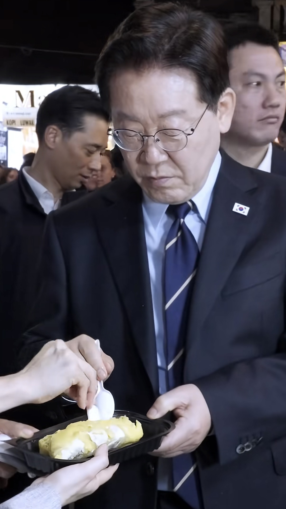 South Korea’s president dons conical hat, samples durian on Hanoi streets - Ảnh 4.