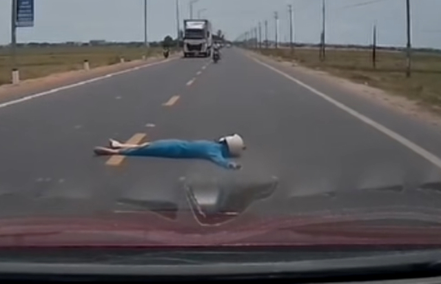 Vietnam police investigate viral clip of woman lying on road to block car- Ảnh 1. Vietnam police investigate viral clip of woman lying on road to block car- Ảnh 1.
