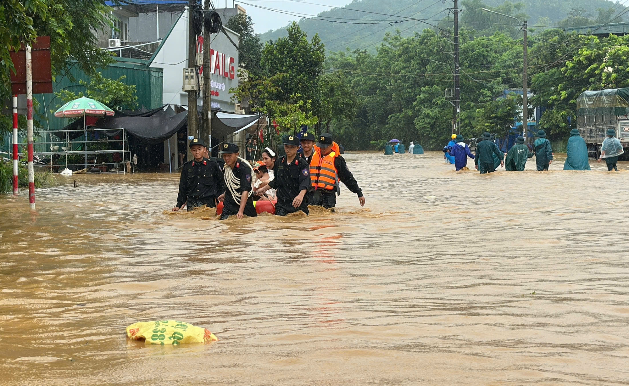 Cảnh sát dầm mưa đưa người dân, tài sản khỏi vùng ngập sâu - Ảnh 1.