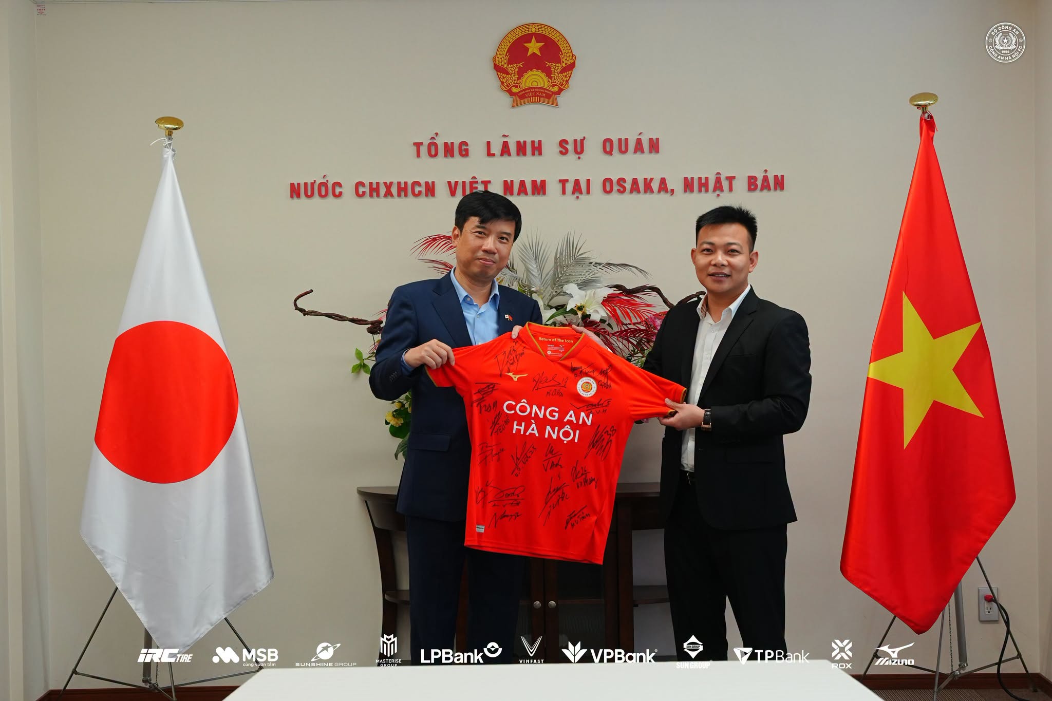 Tổng lãnh sự Nguyễn Trường Sơn nhận áo thi đấu có chữ ký của toàn đội CLB Công An Hà Nội từ tay Phó giám đốc điều hành Nguyễn Văn Việt - Ảnh: CAHNFC