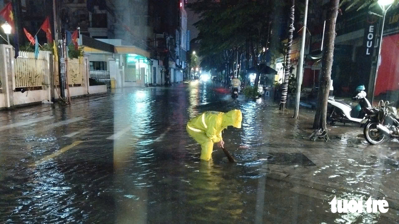 Công nhân ứng trực giữa đêm, ăn vội bánh mì để quay trở lại tiêu thoát nước cho Hà Nội ngày mưa lớn - Ảnh 1.
