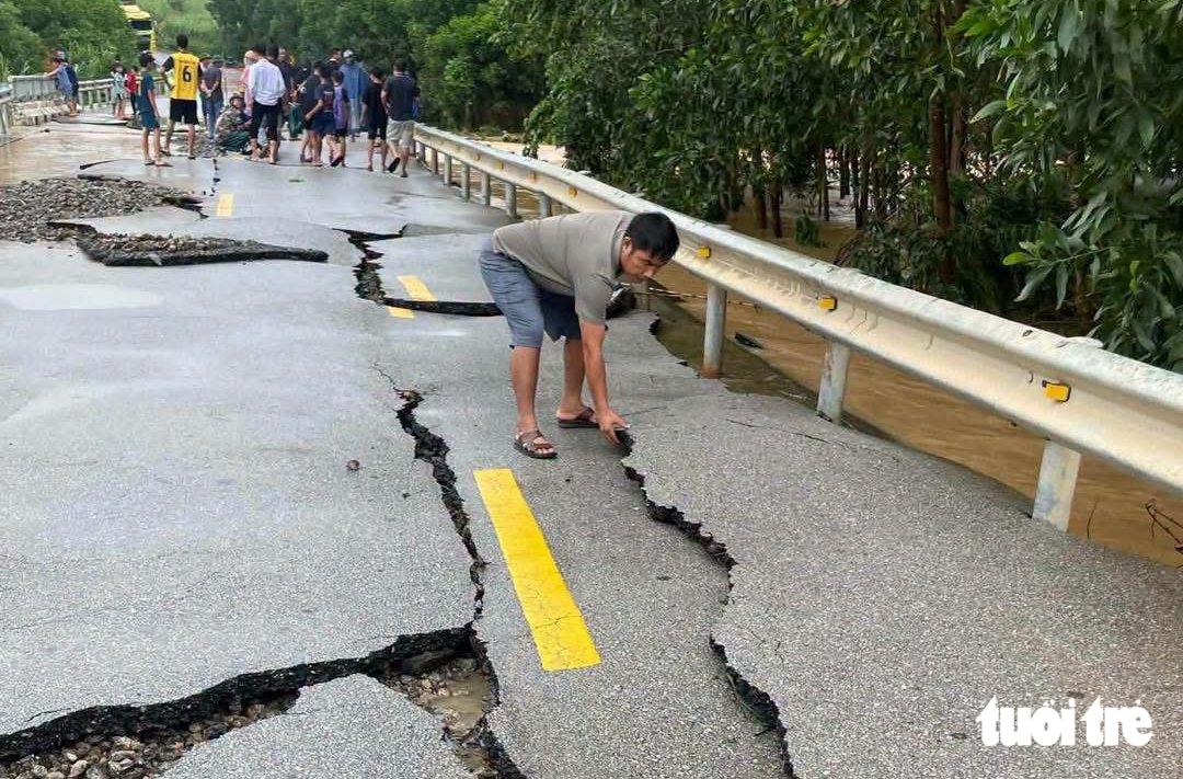 Nước lũ rút, lộ mặt đường quốc lộ vỡ như 'bánh đa vỡ' - Ảnh 1.