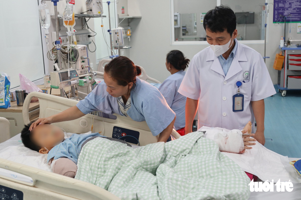7 giờ phẫu thuật ghép tạm bàn tay vào chân bé trai bị cổng chào sập đè - Ảnh 1.