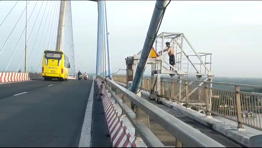 Người đàn ông leo lên lan can cầu Mỹ Thuận 1 tập thể dục, tiềm ẩn nguy hiểm - Ảnh 2.