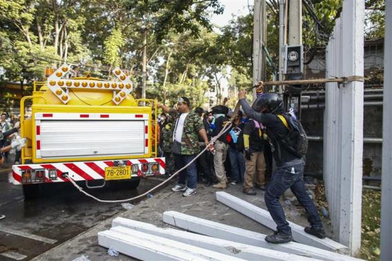 Người biểu tình giật đổ rào chắn của sân vận động sáng 26-12. Ảnh: REUTERS