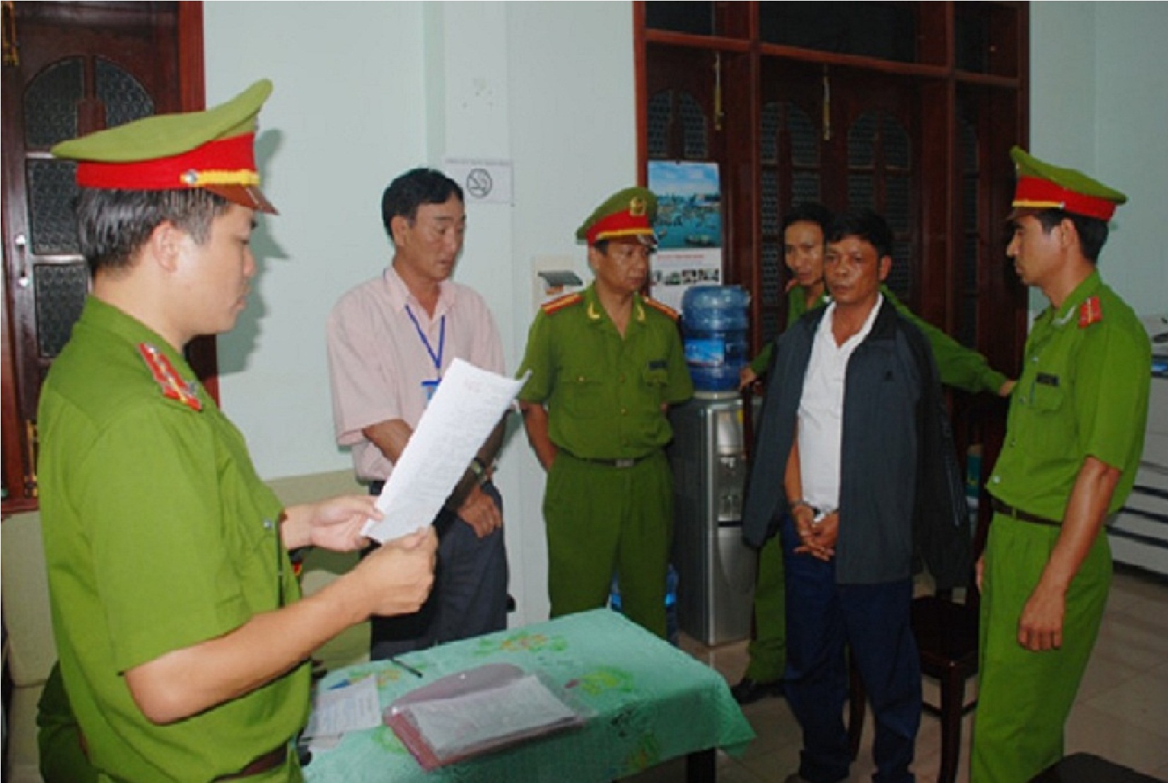 Ông Lê Đình Trọng (áo đen) nghe đọc lệnh bắt