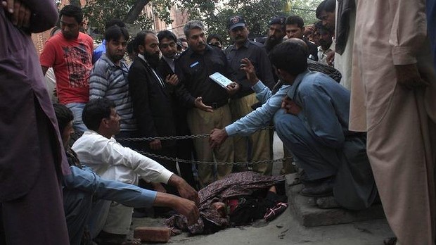 Police collect evidence near the body of Farzana Iqbal, who was killed by family members outside Lahore High Court for marrying the man she loved.