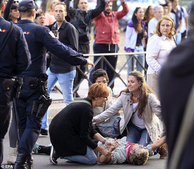 Frenzied: A woman is helped after fainting following the exit of the van transporting Excalibur in Alcorcon, Spain