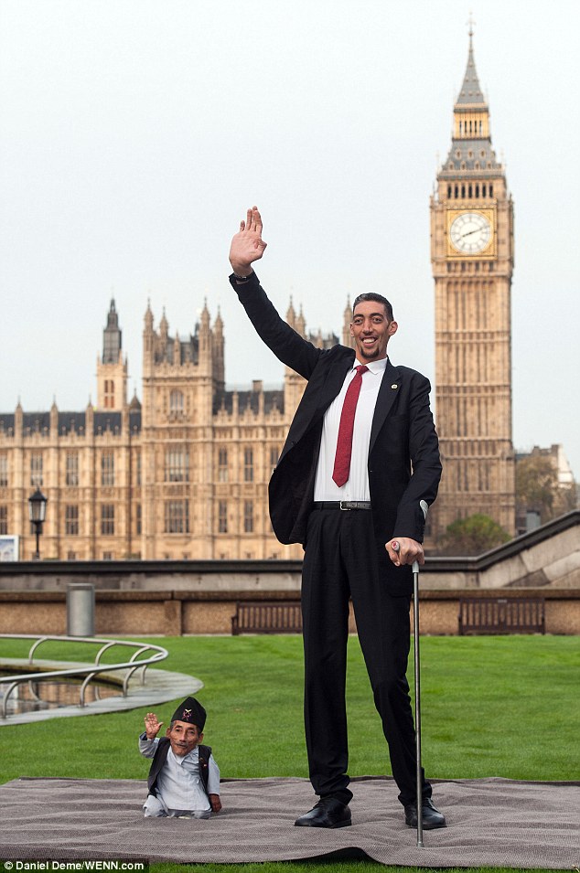 (Very) high five: Mr Dangi, who measures just 22.5 ins, and 8ft 1in tall Mr Kosen, meet in London today