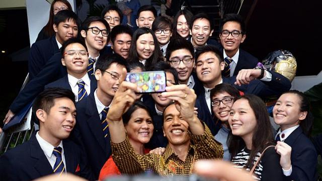 &Ocirc;ng Widodo chụp h&igrave;nh với con trai v&agrave; bạn b&egrave; của cậu tại Singapore. Ảnh: Straits Times