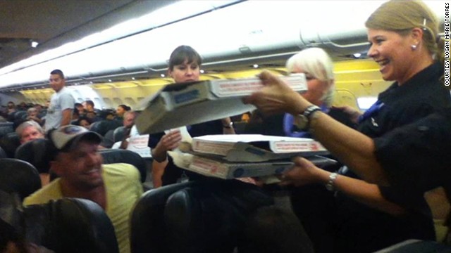 Phi h&agrave;nh đo&agrave;n ph&aacute;t pizza cho h&agrave;nh kh&aacute;ch. Ảnh: CNN