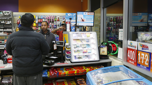 Employee Gurcharam Sohel, center, helps customer, this store sold one of the $400 million lottery ticket at Dixon Landing gas station in the Food Mart in