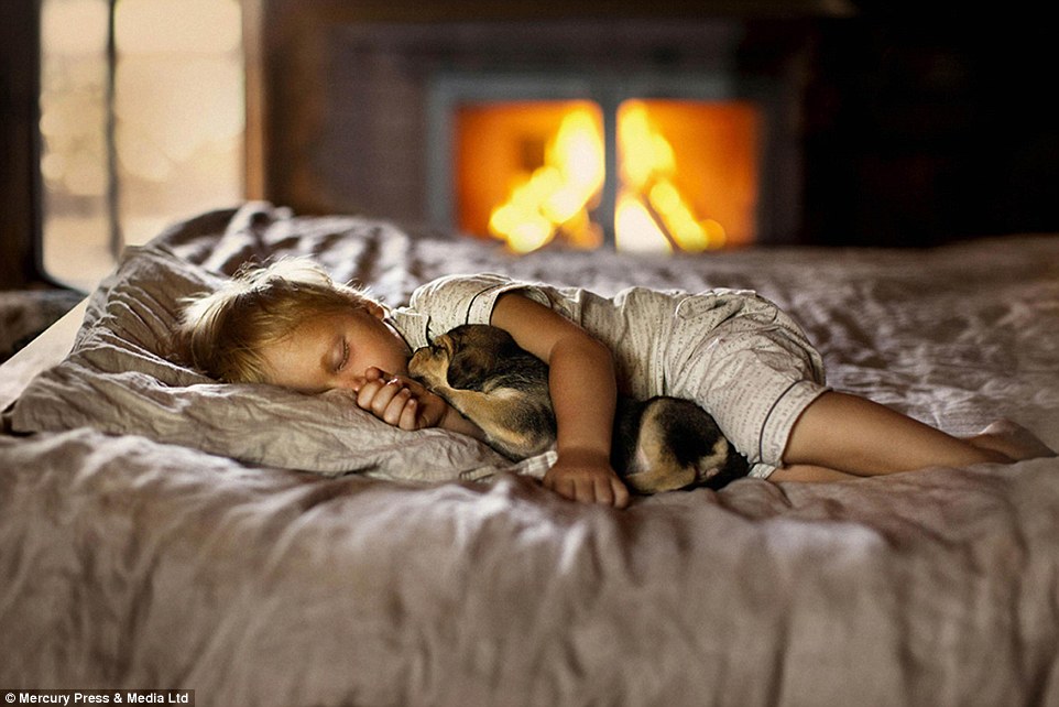 A child drifts off to sleep while cuddling her puppy - the photographer said she felt inspired while capturing the moving moments&nbsp;