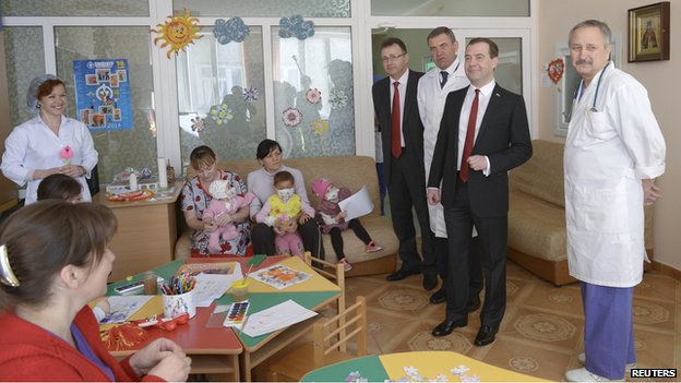 Russias Prime Minister Dmitry Medvedev (2nd R, front) visits a childrens hospital in the Crimean city of Simferopol, March 31, 2014