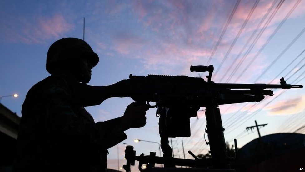 A Thai soldier mans his machine gun atop a military vehicle outside the Centre for the Administration of Peace and Order (20 May 2014)