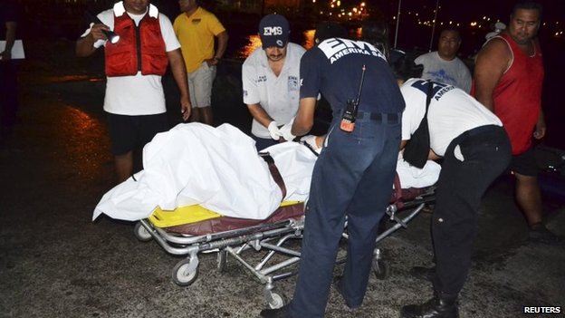 Thi thể chàng thiếu niên 17 tuổi được đưa vào bờ, còn cha cậu vẫn mất tích. Ảnh: Reuters