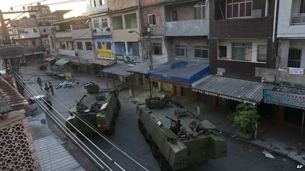 Qu&acirc;n đội Brazil v&agrave; xe bọc th&eacute;p &aacute;p s&aacute;t khu ổ chuột Mare s&aacute;ng sớm 30-3. Ảnh: AP