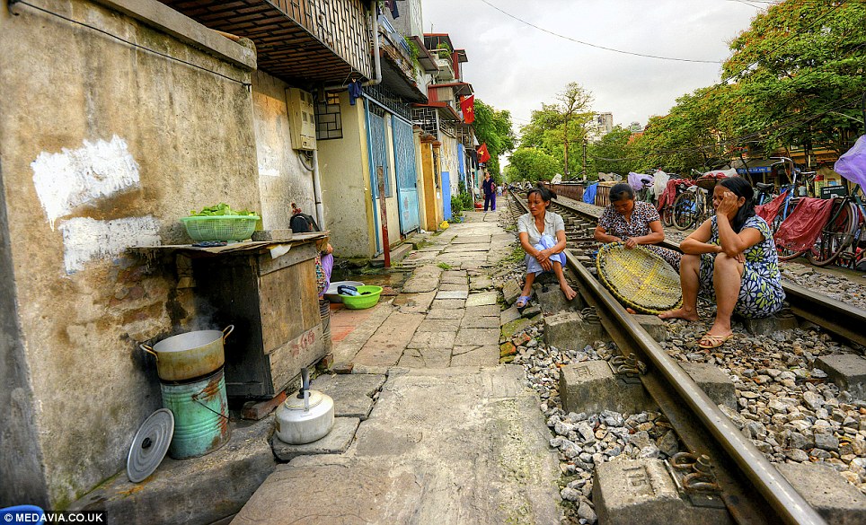 Unusual sight: The photographer said there are barbershops, people selling goods, chefs cooking food and kids running around - all within inches of the tracks