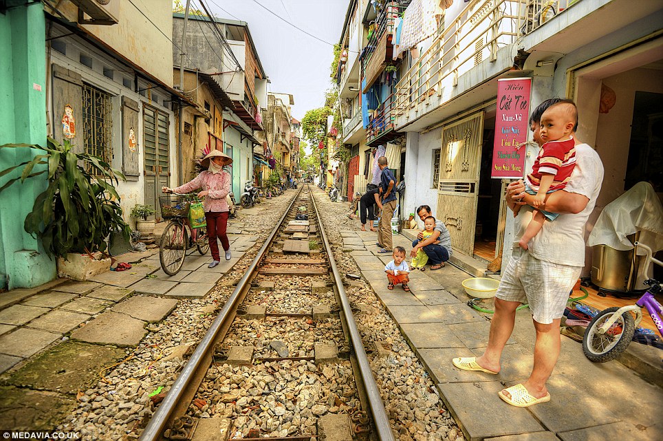 On camera: Ashit Desai, 54, of Bangalore, India, photographed the people who live next to the railway while he was on holiday in Vietnams capital city