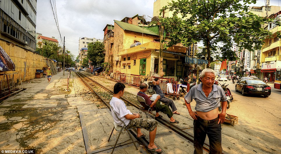 Paying attention: Residents have to move out of the way and even dismantle shop displays when the train is approaching