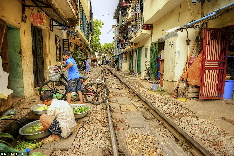 Knowing the timetable: When the track is clear after a train has passed, local residents move back into the middle of the line