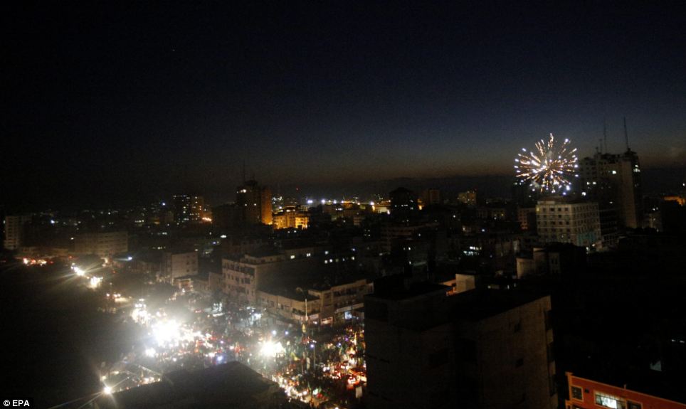 Fireworks: Palestinians set off fireworks as the gather in the streets after Israel and Hamas agreed what it was hoped would be a long-term truce