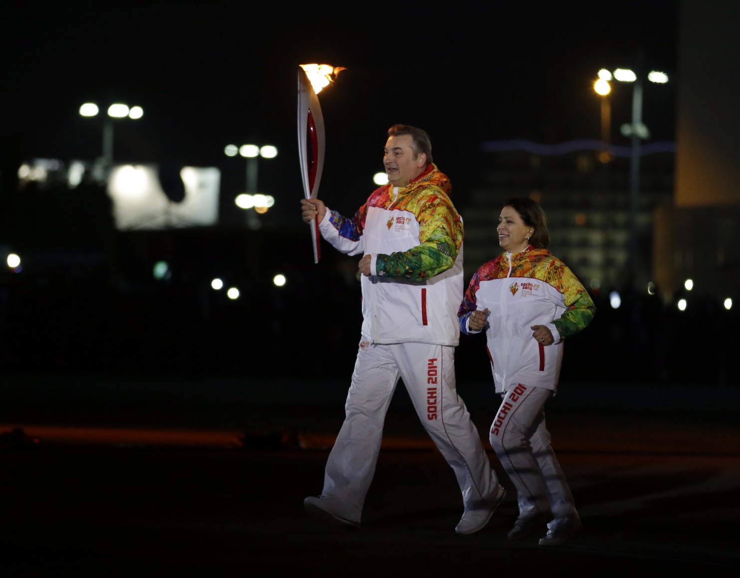 B&agrave; Irina Rodninav&agrave; huyền thoại kh&uacute;c c&ocirc;n cầu Vladislav Tretiak rước đuốc Olympic. Ảnh: AP