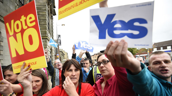 Pro and anti-independence supporters wave posters outside a campaign event in favour of the union in Clydebank, Scotland, September 16, 2014. (Reuters/Dylan Martinez)