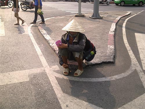 Một người đ&agrave;n &ocirc;ng khỏe mạnh, l&agrave;nh lặn, đội n&oacute;n l&aacute; lụp xụp cố t&igrave;nh che giấu khu&ocirc;n mặt... c&ograve;n trẻ ngồi chờ bố th&iacute; tại ng&atilde; tư Bảy Hiền (quận T&acirc;n B&igrave;nh)