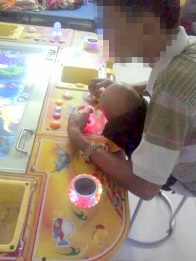 Một nam thanh niên đang say mê trò bắn cá ở một tiệm game trên đường Hiệp Bình, quận Thủ Đức, TP HCM